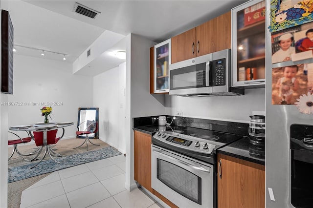 kitchen with light tile patterned floors and stainless steel appliances