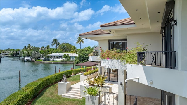 balcony featuring a patio, a water view, and a boat dock