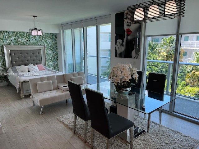 bedroom with expansive windows, access to exterior, and light hardwood / wood-style flooring