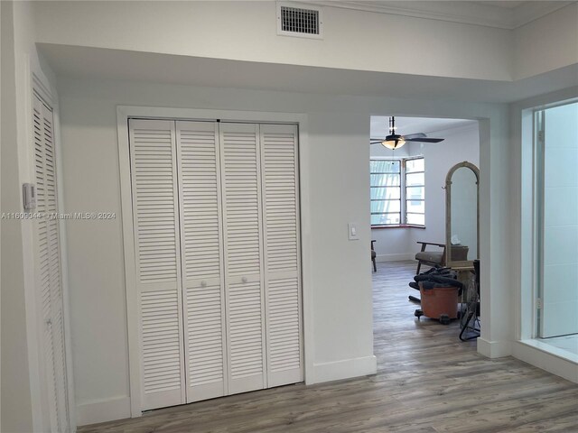 hall with hardwood / wood-style floors and crown molding