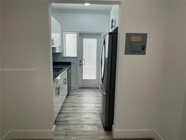 kitchen with appliances with stainless steel finishes, white cabinetry, plenty of natural light, and light wood-type flooring