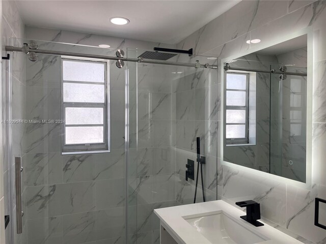 bathroom featuring tile walls, a shower with door, and vanity