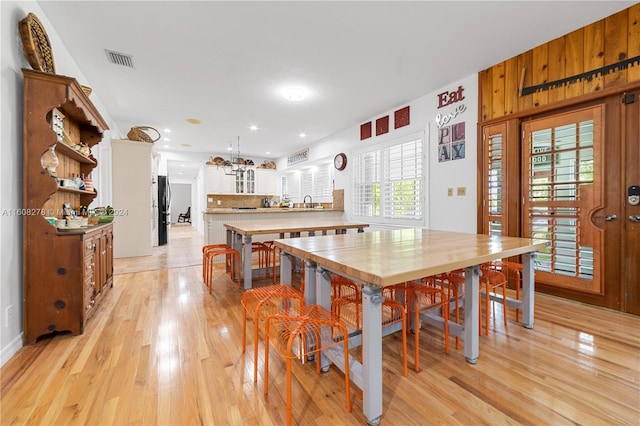 dining room with wood walls and light hardwood / wood-style floors