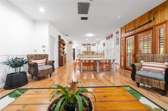 living room featuring wooden walls and light hardwood / wood-style floors