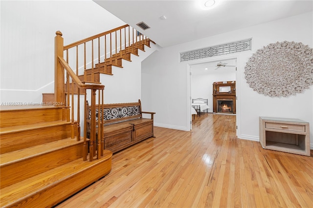 stairs with hardwood / wood-style floors and ceiling fan