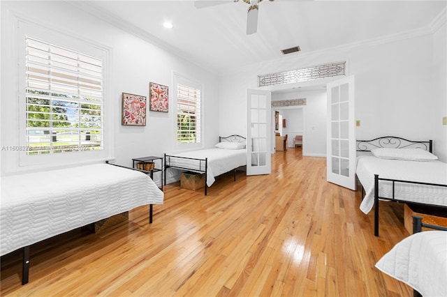 bedroom with french doors, ceiling fan, crown molding, and hardwood / wood-style floors