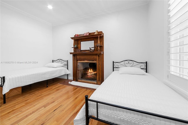 bedroom with wood-type flooring and ornamental molding