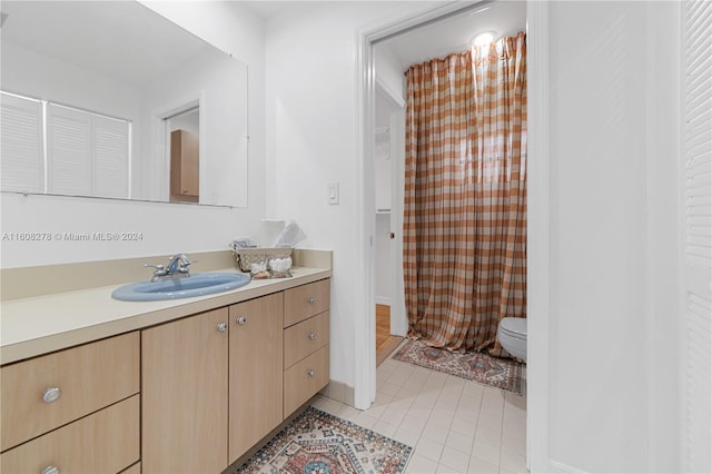 bathroom with tile patterned flooring, vanity, and toilet