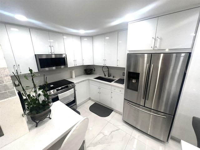 kitchen with sink, white cabinets, and appliances with stainless steel finishes