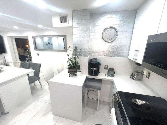 kitchen with white cabinetry and range with electric cooktop