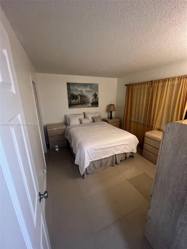 bedroom featuring tile patterned floors and a textured ceiling