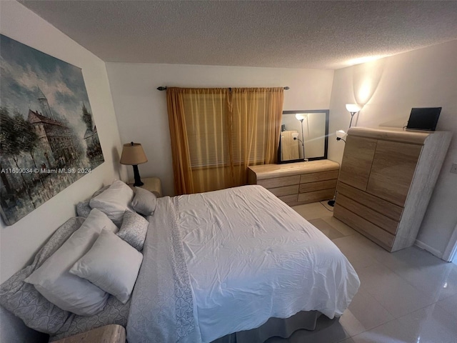 bedroom with light tile patterned flooring and a textured ceiling