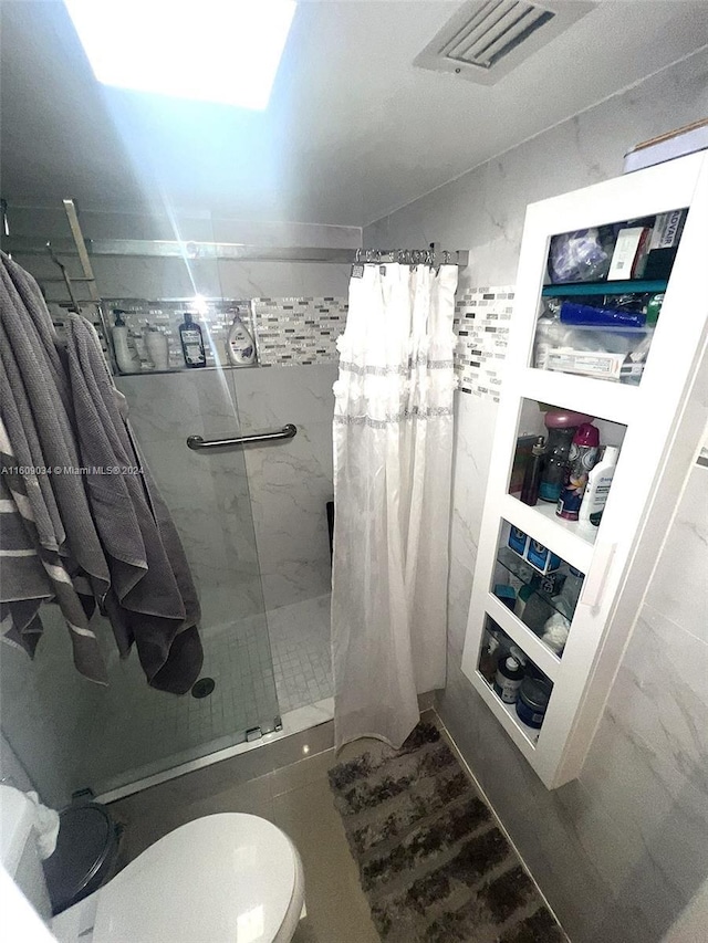 bathroom with a shower with curtain and toilet