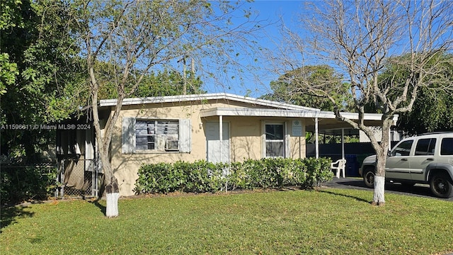 view of front of home with a carport and a front yard