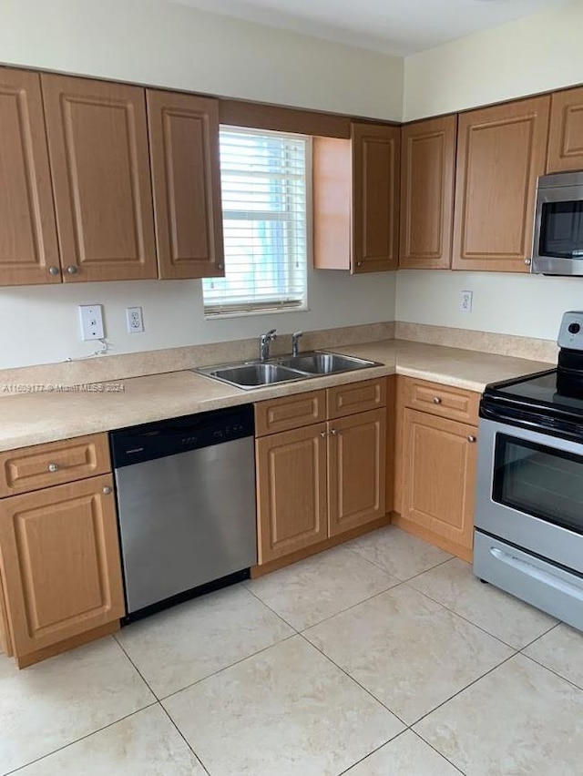 kitchen with sink, light tile floors, and appliances with stainless steel finishes