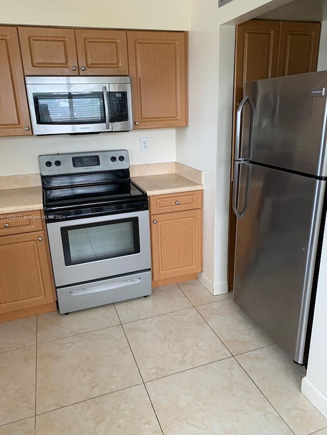 kitchen featuring appliances with stainless steel finishes and light tile flooring