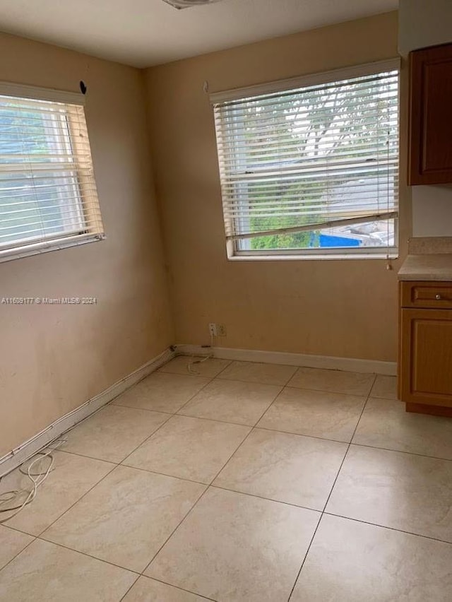 unfurnished room with a wealth of natural light and light tile flooring