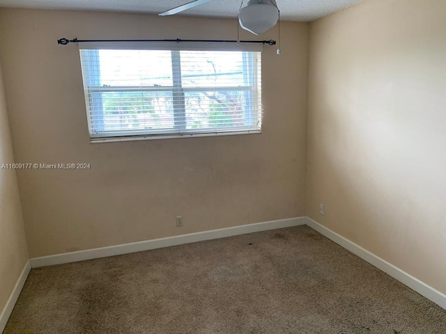 carpeted empty room with a textured ceiling