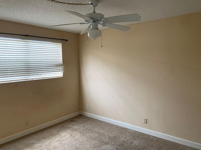 carpeted empty room featuring ceiling fan and a textured ceiling