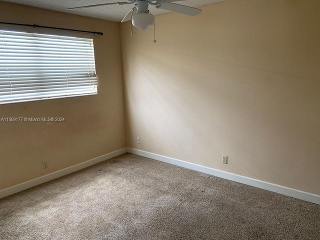 carpeted spare room with ceiling fan