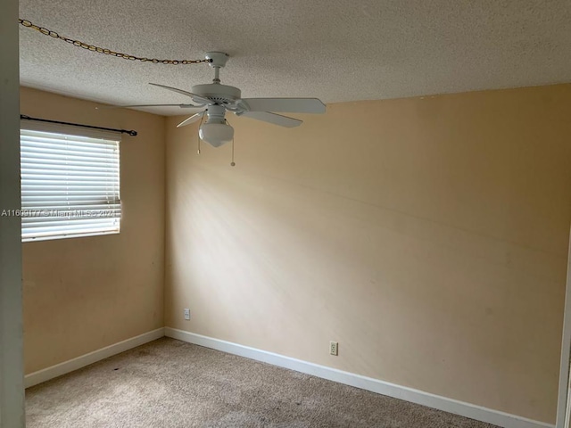 empty room featuring carpet, ceiling fan, and a textured ceiling