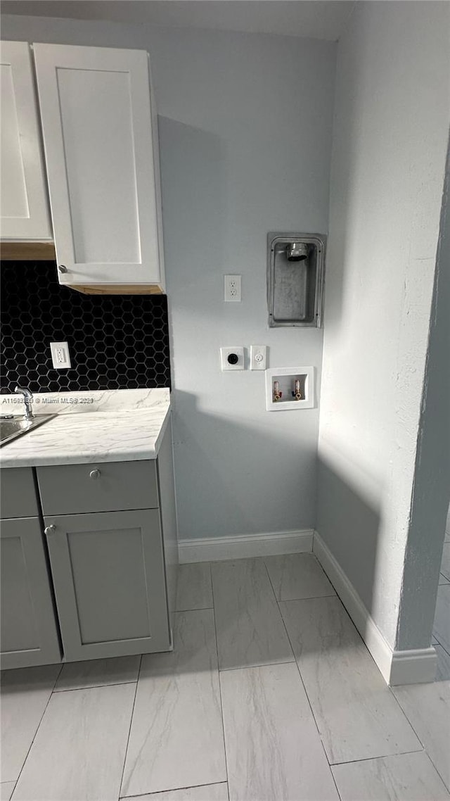 washroom featuring electric dryer hookup, washer hookup, and cabinets