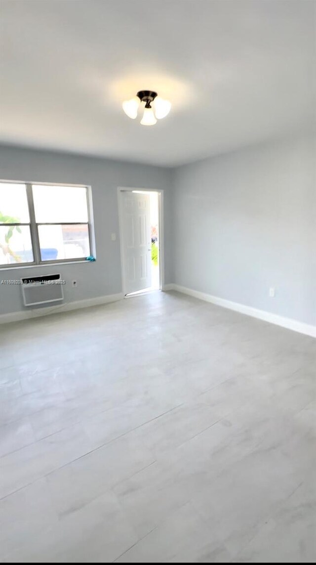 unfurnished room with a wall mounted AC