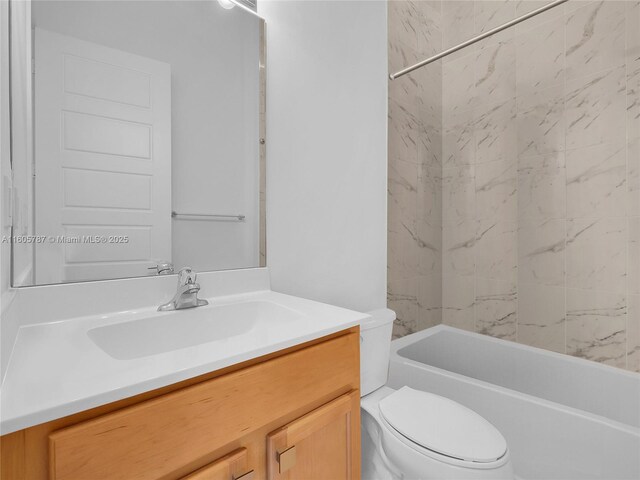 full bathroom with vanity, tiled shower / bath combo, and toilet