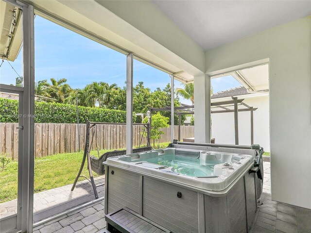 sunroom featuring a jacuzzi