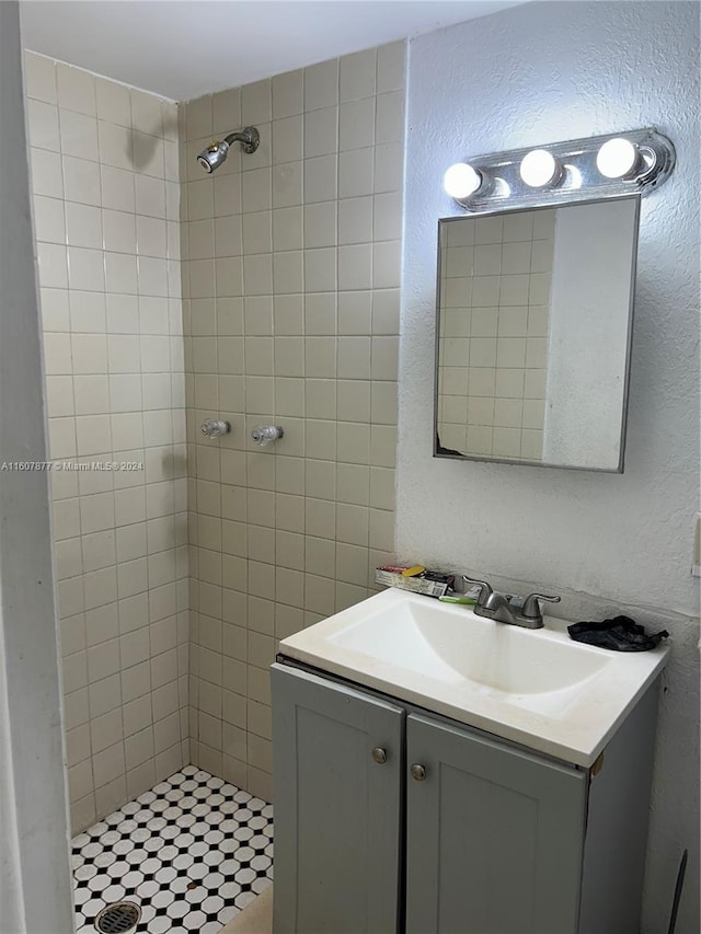 bathroom with a tile shower and vanity