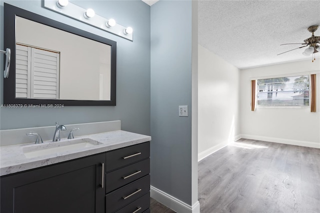 bathroom with vanity, a textured ceiling, wood-type flooring, and ceiling fan