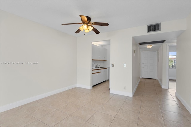 tiled empty room featuring sink and ceiling fan