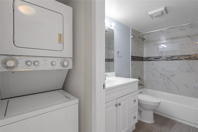 full bathroom with vanity, stacked washer / dryer, toilet, and tiled shower / bath