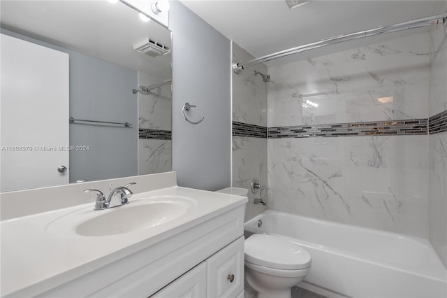 full bathroom featuring vanity, tiled shower / bath, and toilet