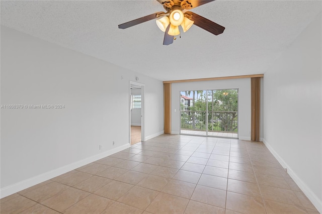 tiled spare room with ceiling fan and a textured ceiling