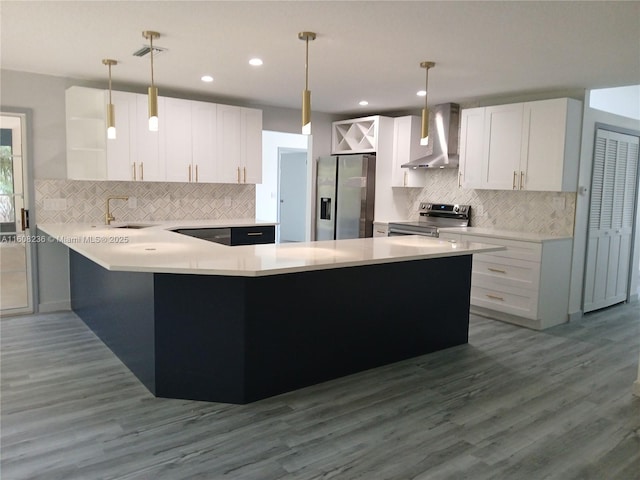 kitchen with decorative light fixtures, open shelves, stainless steel appliances, white cabinetry, and wall chimney range hood