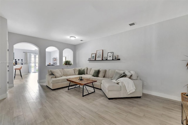 living room with french doors and light hardwood / wood-style flooring