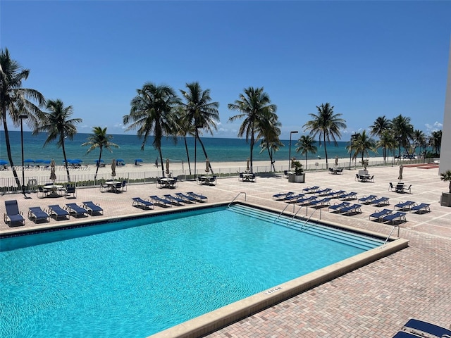 view of swimming pool featuring a patio and a water view