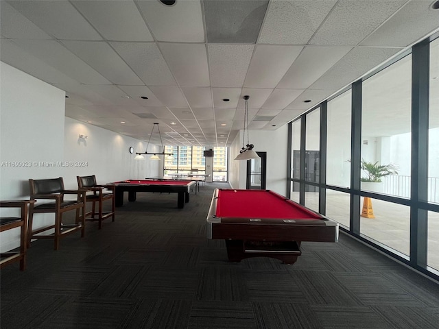 rec room with a drop ceiling, a wall of windows, dark carpet, and billiards