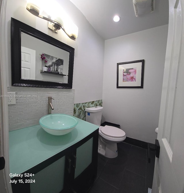 bathroom featuring tile patterned flooring, vanity, toilet, and decorative backsplash