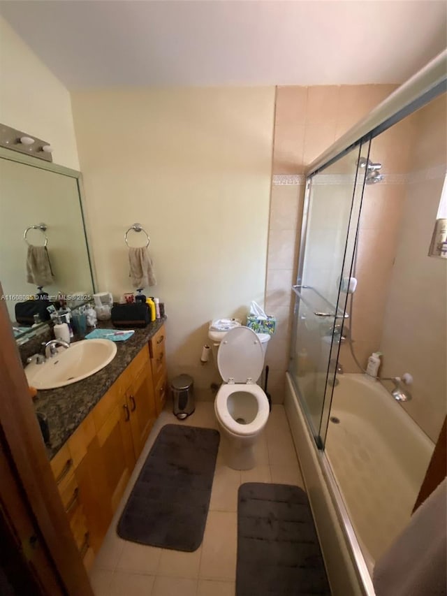 full bathroom with tile patterned floors, vanity, enclosed tub / shower combo, and toilet