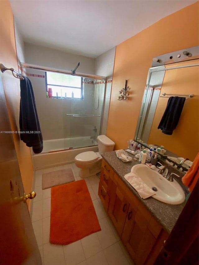 full bathroom with tile patterned flooring, vanity, toilet, and shower / bath combination with glass door