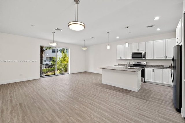 kitchen with white cabinetry, a center island with sink, stainless steel appliances, light wood-type flooring, and hanging light fixtures