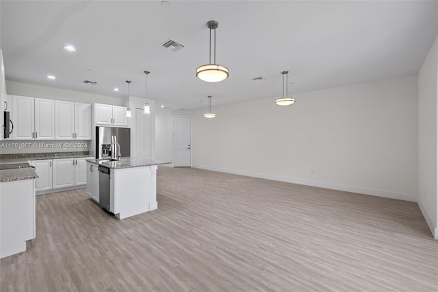 kitchen featuring hanging light fixtures, a kitchen island with sink, appliances with stainless steel finishes, and white cabinetry