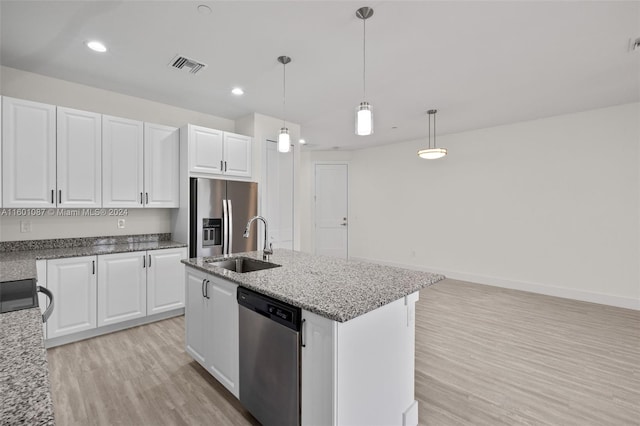 kitchen featuring white cabinetry, stainless steel appliances, a kitchen island with sink, hanging light fixtures, and sink