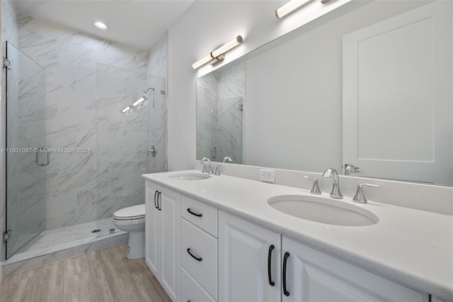 bathroom with hardwood / wood-style flooring, toilet, a shower with door, and vanity