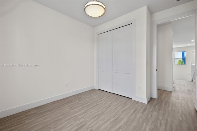 unfurnished bedroom featuring a closet and light hardwood / wood-style flooring