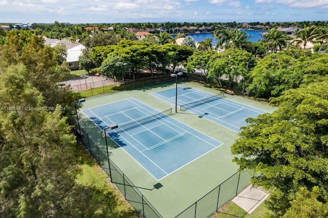 view of tennis court featuring a water view