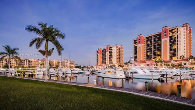 view of home's community with a boat dock, a lawn, and a water view