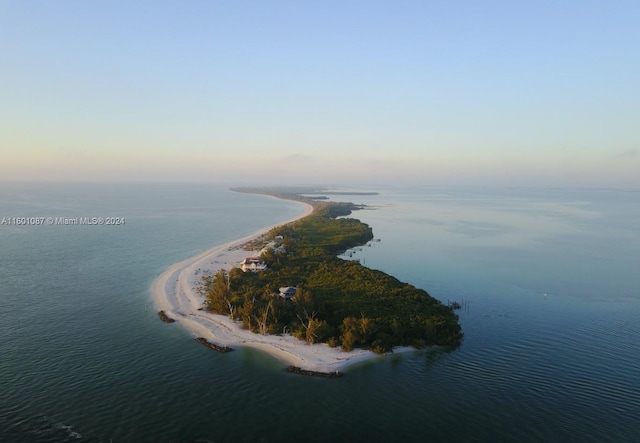 aerial view at dusk featuring a water view